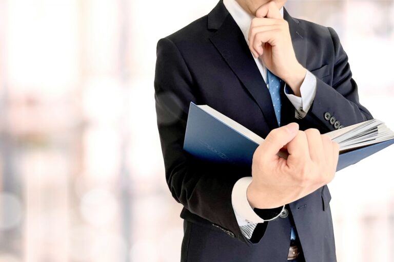 手帳を手に採用の論点を整理するビジネスパーソン